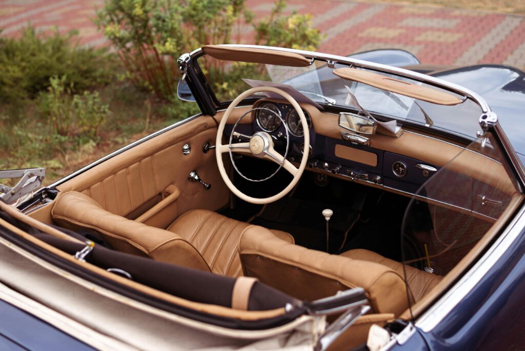 Top down view of a vintage convertible car interior showcasing leather seats and classic design.